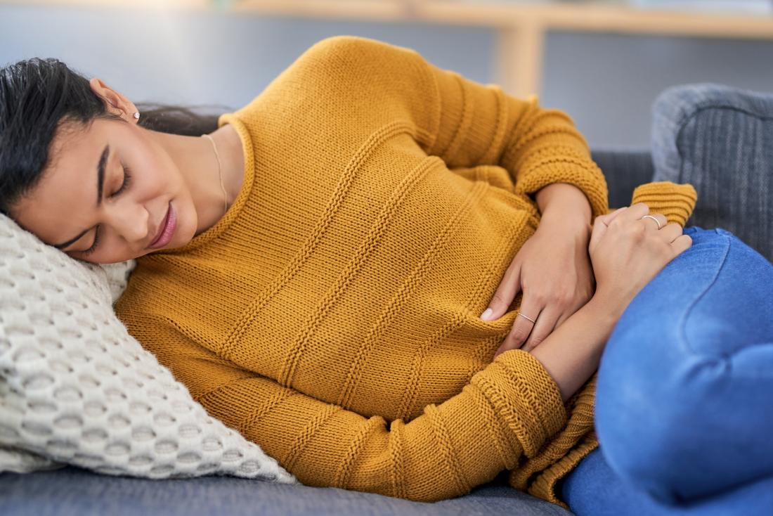 https://post.medicalnewstoday.com/wp-content/uploads/sites/3/2019/09/a-woman-lying-on-the-sofa-and-experiencing-uterus-pain-early-pregnancy.jpg