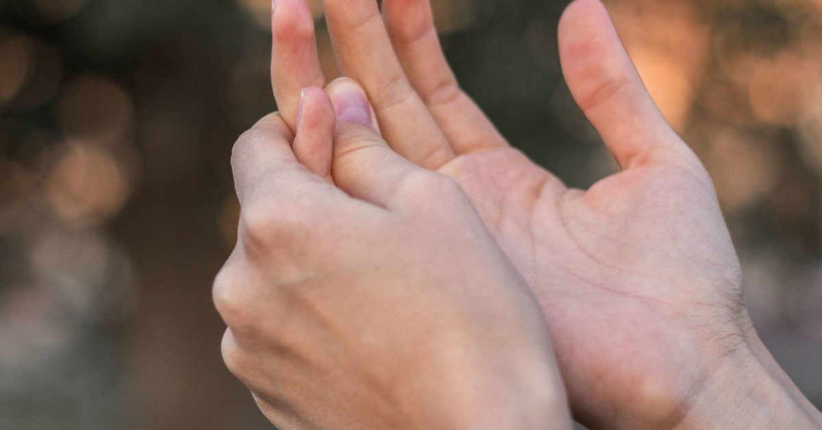 Left hand massaging the right pinky finger