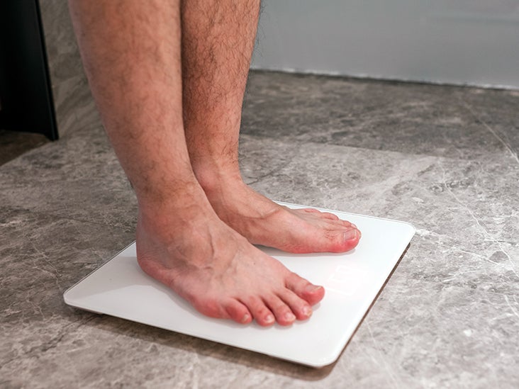 Top view of feet on weighing scale. Women weigh on a weight