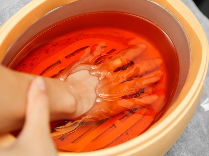Photo Female hands in a paraffin wax bowl