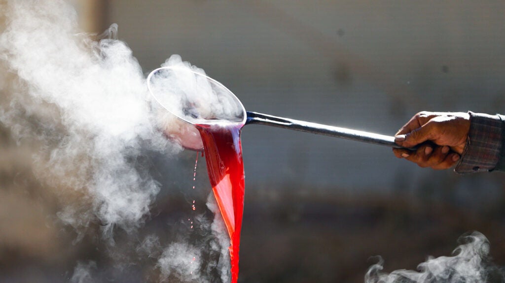 A person extracting molasses from sugar.