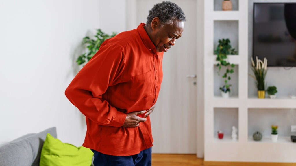 a person in a red sweater is holding their stomach